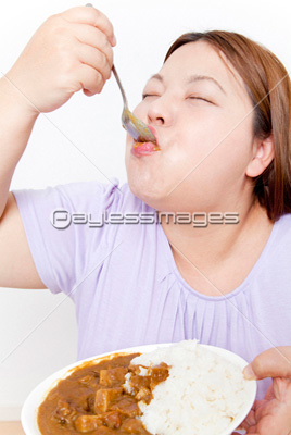 カレーを食べる肥満の女性 商用利用可能な写真素材 イラスト素材ならストックフォトの定額制ペイレスイメージズ