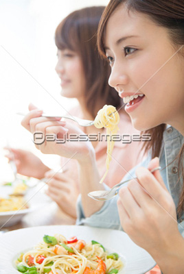 パスタを食べる女性達 商用利用可能な写真素材 イラスト素材ならストックフォトの定額制ペイレスイメージズ