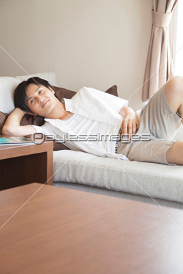 ソファに寝転ぶ男性 ストックフォトの定額制ペイレスイメージズ