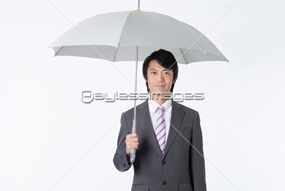 傘を差すビジネスマン ストックフォトの定額制ペイレスイメージズ