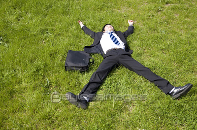 芝生で寝転ぶビジネスマン ストックフォトの定額制ペイレスイメージズ