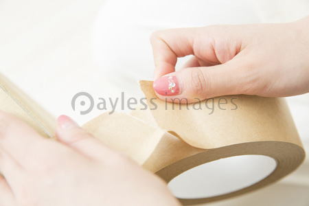 ガムテープを貼る女性の手元 ストックフォトの定額制ペイレスイメージズ