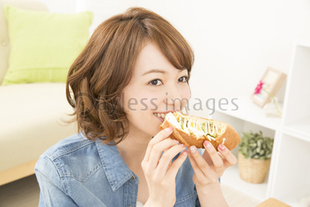 パンを食べる女性 商用利用可能な写真素材 イラスト素材ならストックフォトの定額制ペイレスイメージズ