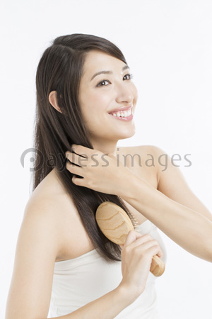 ヘアブラシで髪をとく女性 ストックフォトの定額制ペイレスイメージズ