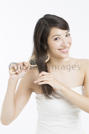ヘアブラシで髪をとく女性 ストックフォトの定額制ペイレスイメージズ