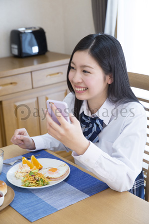 食事をしながらスマホを見る女子高校生 商用利用可能な写真素材 イラスト素材ならストックフォトの定額制ペイレスイメージズ
