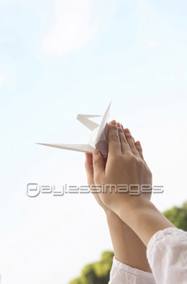 折り紙の鶴を持つ女性の手