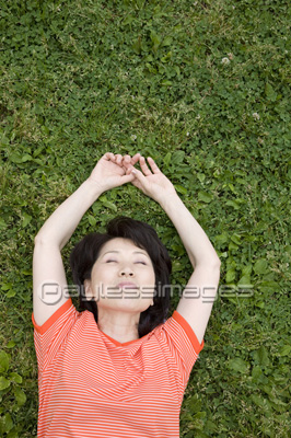 公園の芝生に仰向けに寝転がる女性 無料写真素材 フリー素材