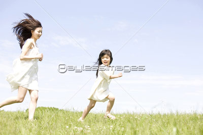 草原を走る女性と女の子 ストックフォトの定額制ペイレスイメージズ