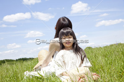 草原に座る女の子 商用利用可能な写真素材 イラスト素材ならストックフォトの定額制ペイレスイメージズ