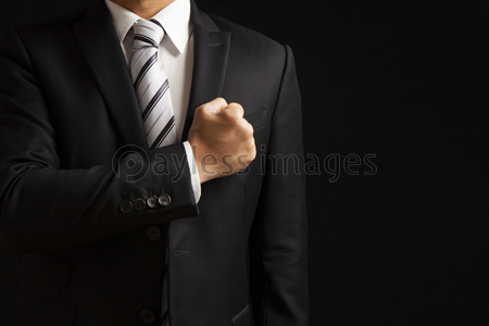 拳を胸にあてるビジネスマン ストックフォトの定額制ペイレスイメージズ