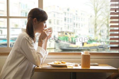 カフェでくつろぐ女性 ストックフォトの定額制ペイレスイメージズ