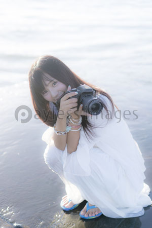 海辺でカメラを構える女性 商用利用可能な写真素材 イラスト素材ならストックフォトの定額制ペイレスイメージズ
