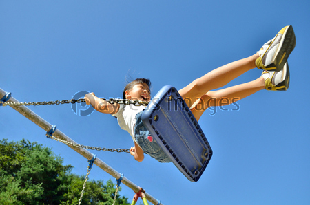 公園のブランコで遊ぶ女の子 ストックフォトの定額制ペイレスイメージズ