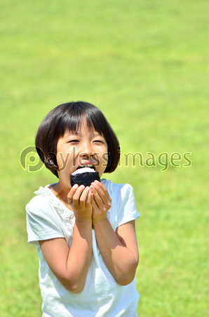 おにぎりを食べる女の子 ストックフォトの定額制ペイレスイメージズ