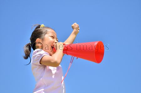 青空で応援する小学生の女の子 メガホン 夏 ストックフォトの定額制ペイレスイメージズ