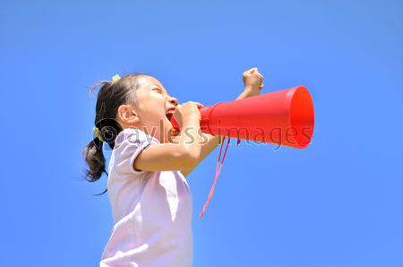 青空で応援する小学生の女の子 メガホン ストックフォトの定額制ペイレスイメージズ