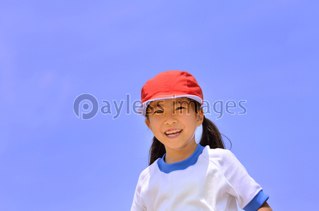 青空でにっこり笑う女の子 体操服 赤白帽子 ストックフォトの定額制ペイレスイメージズ