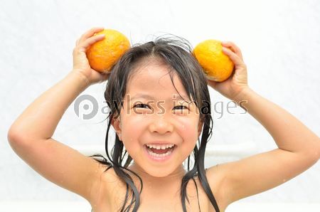 お風呂でユズを持って遊ぶ女の子 ゆず湯 ストックフォトの定額制ペイレスイメージズ