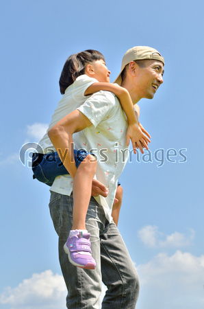 青空でおんぶする親子 夏 ストックフォトの定額制ペイレスイメージズ