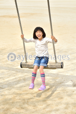 公園のブランコで遊ぶ女の子 ストックフォトの定額制ペイレスイメージズ