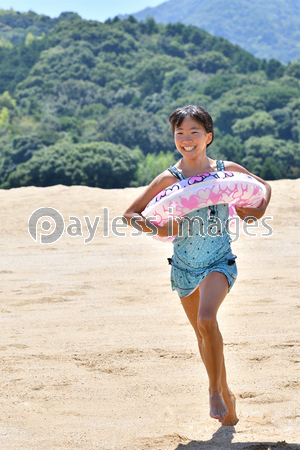 砂浜を走る女の子 海水浴 水着 ストックフォトの定額制ペイレスイメージズ