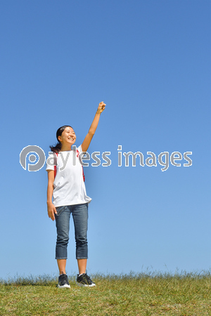 青空でガッツポーズする小学生の女の子 ランドセル ストックフォトの定額制ペイレスイメージズ