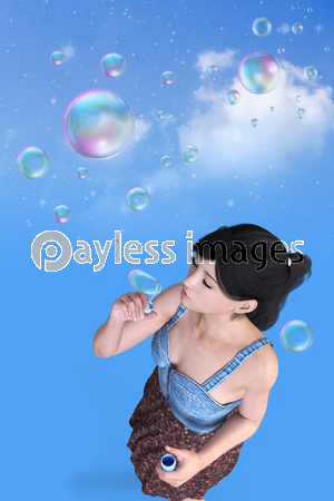 シャボン玉を吹く若い女性が真っ青な空の背景に一人いる 商用利用可能な写真素材 イラスト素材ならストックフォトの定額制ペイレスイメージズ
