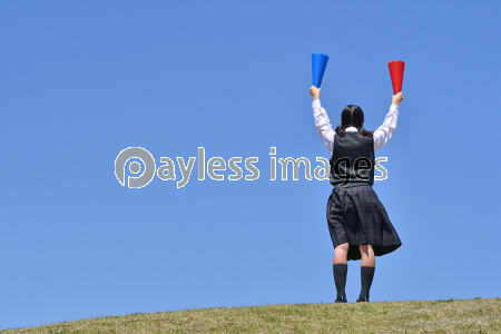 青空で応援する小学生の女の子 メガホン ストックフォトの定額制ペイレスイメージズ