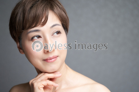 カメラ目線で顎に手を当てる中年の日本人女性 ストックフォトの定額制ペイレスイメージズ