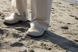 浜に立つ男性の足元