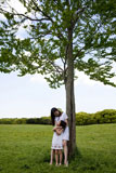 木下で女の子を抱きしめる女性