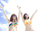 サングラスをかけて手を上げる水着姿の女性2人