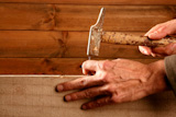Carpenter+hands+with+hammer+wood+and+nail+on+wooden+background