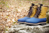 Hiking Boots on the autumn foliage background, selective focus on foreground