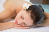 Beautiful woman lying on massage table at spa center